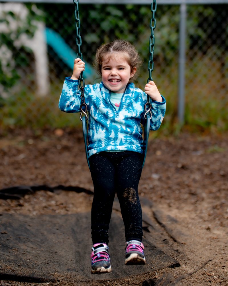 A girl smiling on the swings