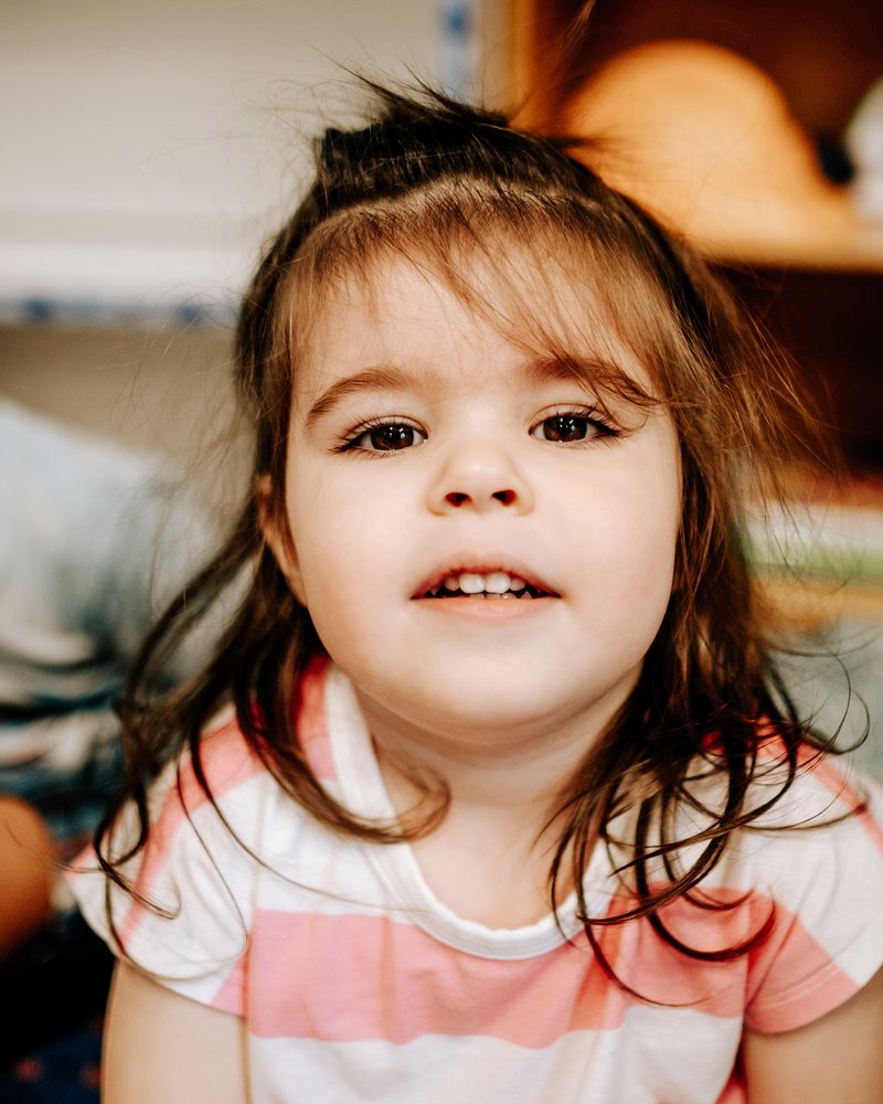 A girl with brown hair looking up at the camera