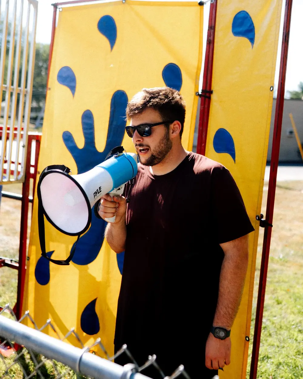 Ganan calling out on a megaphone at the Kids & Co. carnival